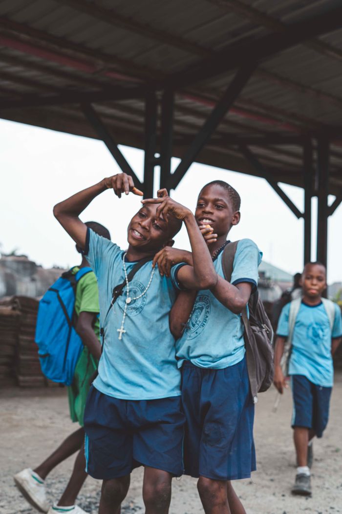 Happy group of African boys in school uniforms enjoying friendship outdoors.