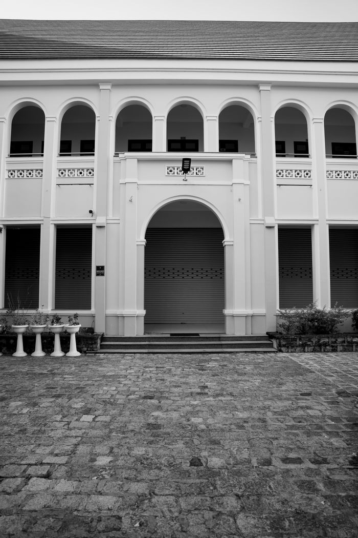 Black and white photo of a historic building with arches and columns.
