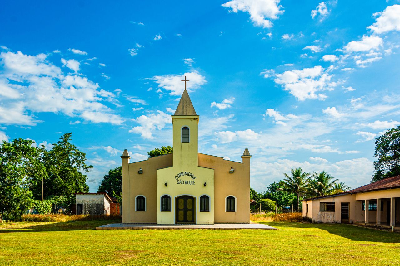 Charming yellow chapel with symmetrical architecture in Araçoiaba da Serra, Brazil, on a sunny day.